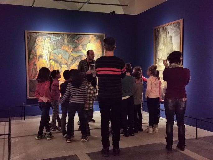 Lo storico dell'arte Jacopo Suggi con una comitiva di bambini davanti a Le grandi bagnanti di André Derain