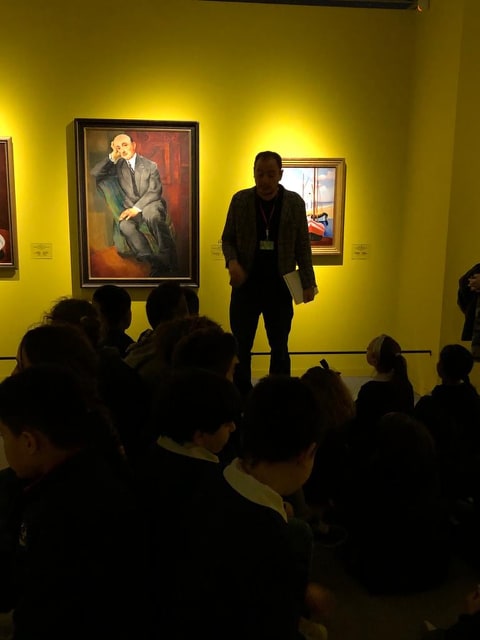 Lo storico dell'arte Jacopo Suggi con i bambini davanti al ritratto di Jonas Netter dipinto da Kisling